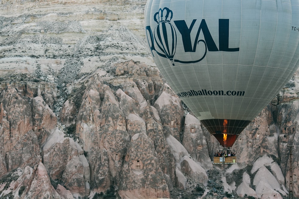 weißer und schwarzer königlicher Heißluftballon in der Nähe des Berges