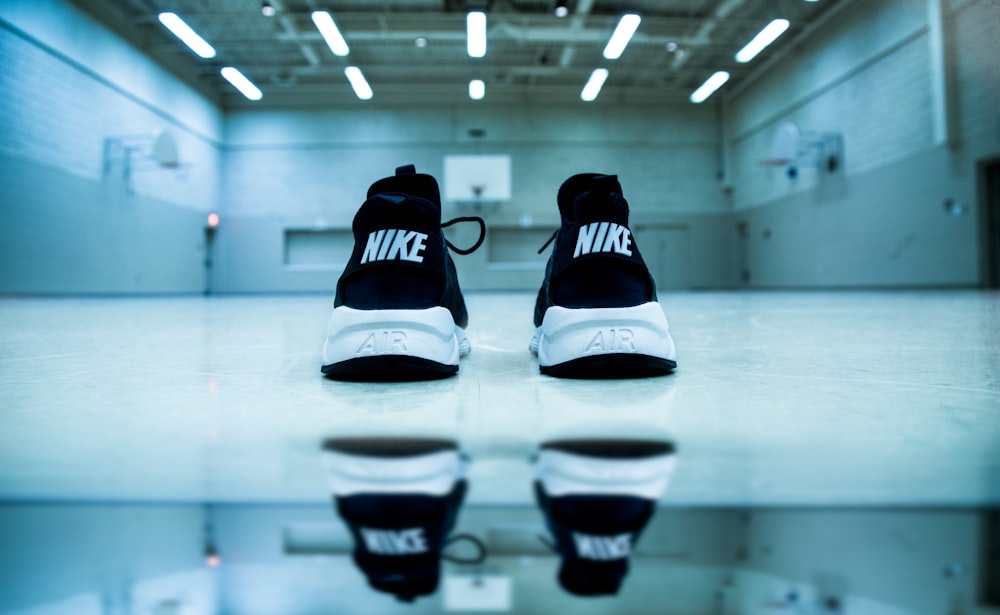 par de tênis esportivos Nike preto e branco