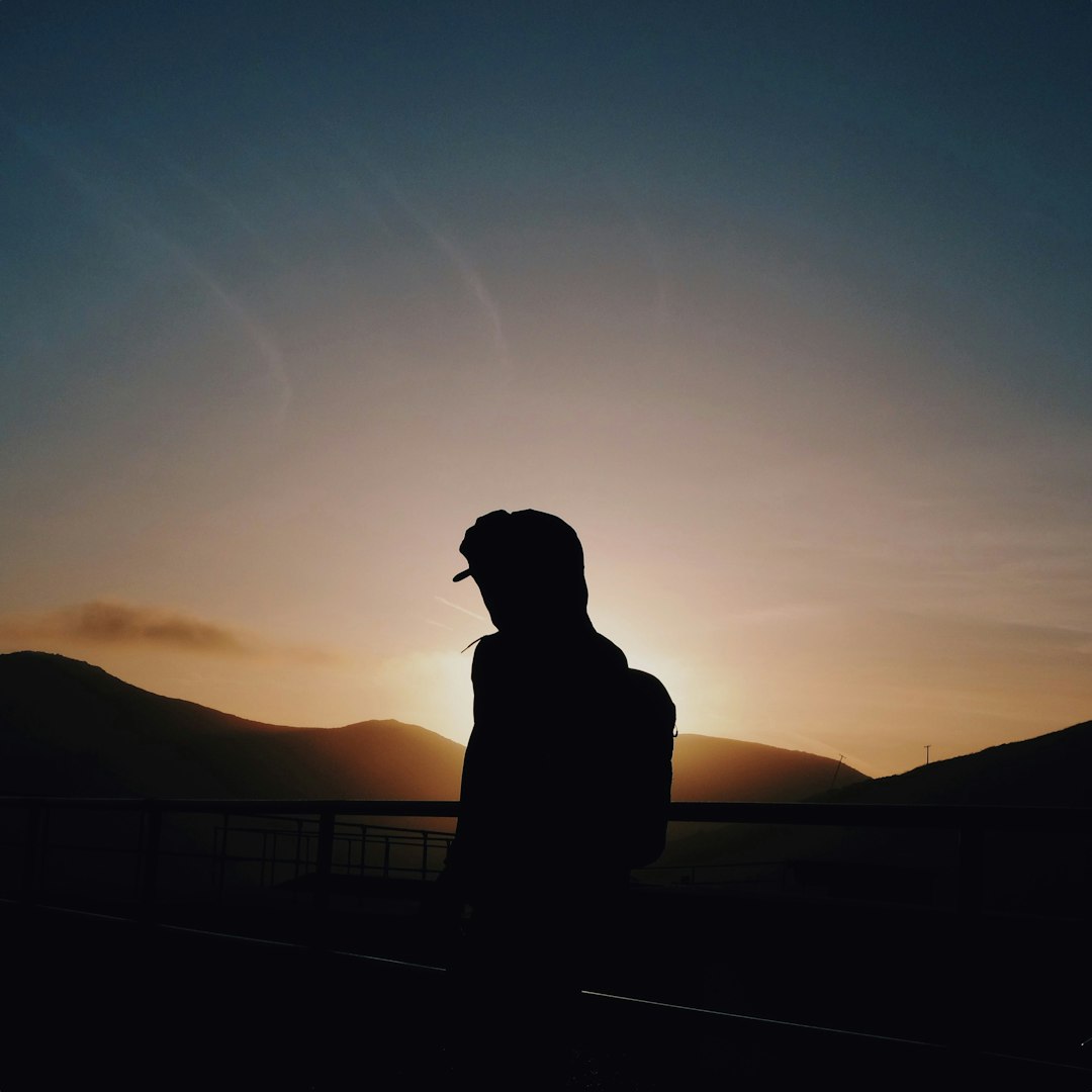 silhouette of man leaning on rails