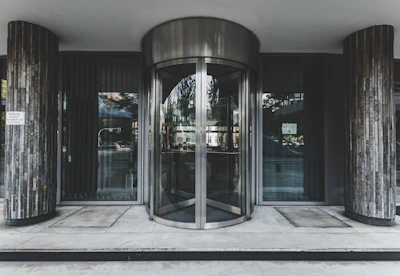 A revolving door system at a hospital entrance with staff and visitors passing through.