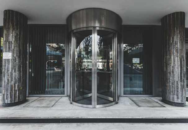 Maintenance technician servicing a revolving door at a busy hospital entrance.