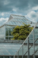 glass greenhouse under cloudy sky