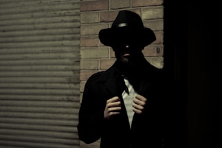 man wearing black fedora hat and black suit jacket