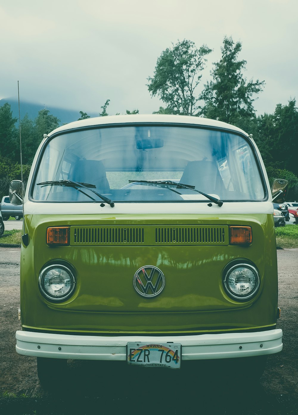 fourgon Volkswagen T2 blanc et vert garé sur une place de parking