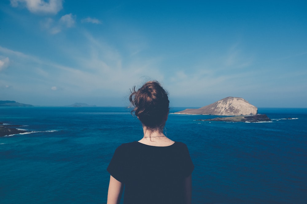 woman standing in front of body of water during daytime