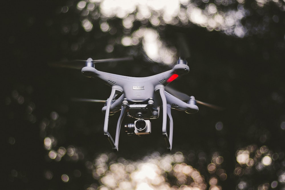 white DJI quadcopter flying selective focus photography