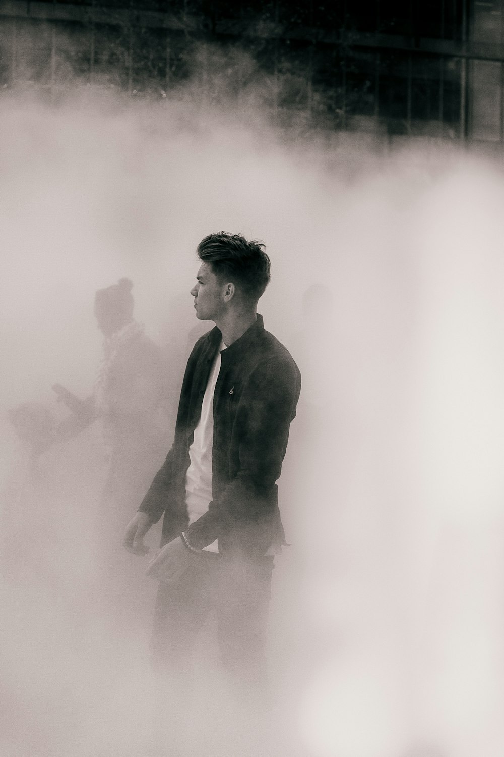 Fashionable man walks out of the fog away from the crowd