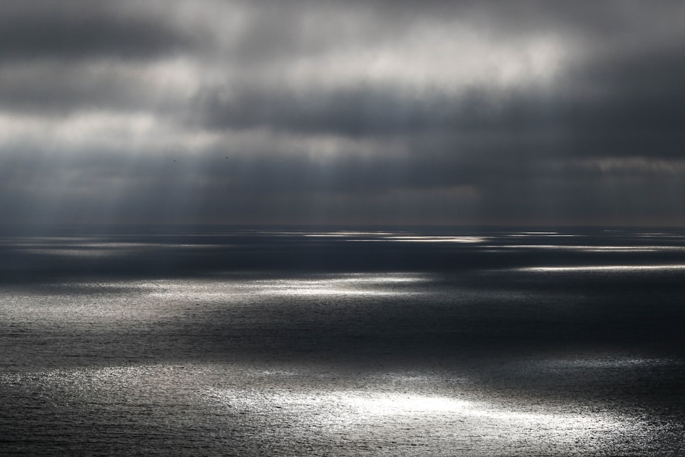 specchio d'acqua sotto il cielo nuvoloso grigio