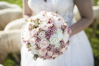 woman holding white and pink petal flower bouquet