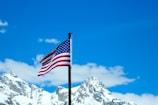 A vibrant South Dakota landscape with a waving American flag under a clear blue sky.