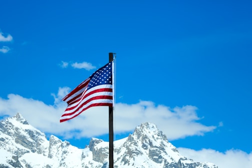 A vibrant South Dakota landscape with a waving American flag under a clear blue sky.