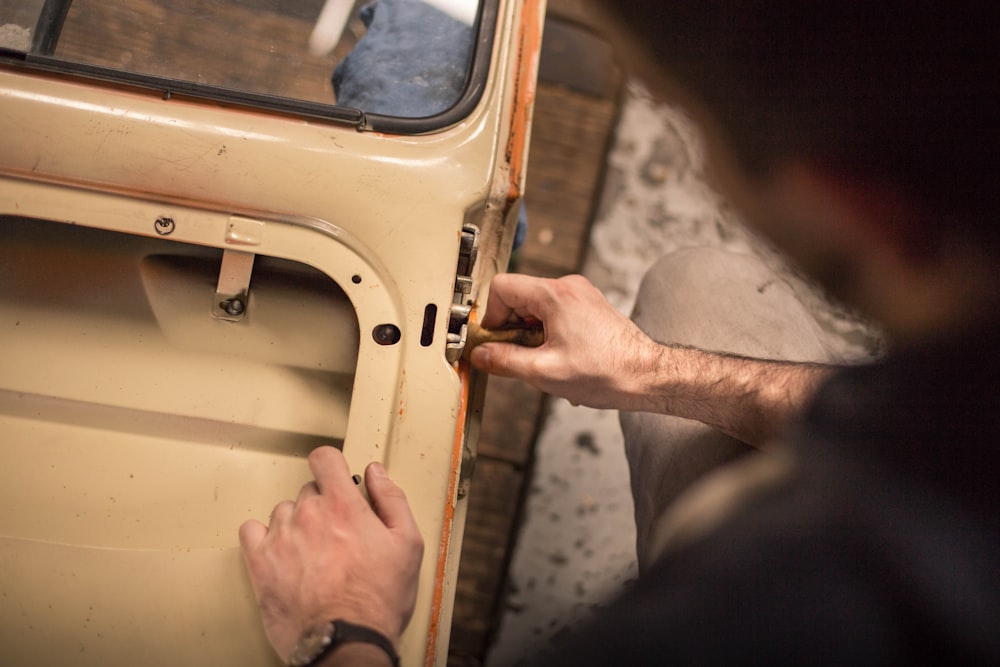 A man adjusting the lock mechanism on a car door