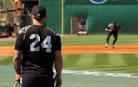 A player practicing footwork drills on the infield dirt under Coach Steve’s watchful eye.