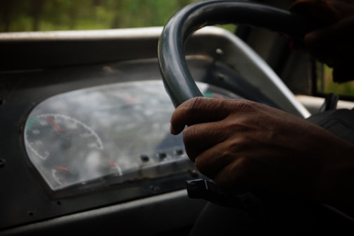 Close-up of hands on the steering wheel following traffic signals carefully.