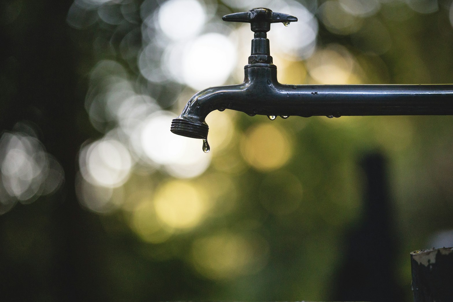 tilt shift lens photography of black steel faucet