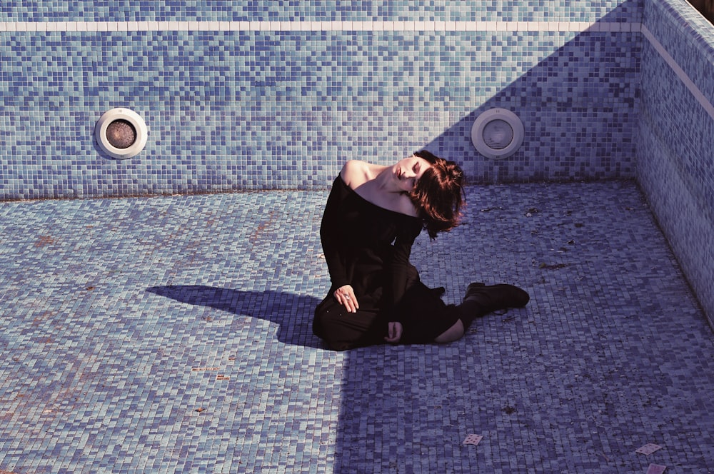 woman sitting inside the empty pool