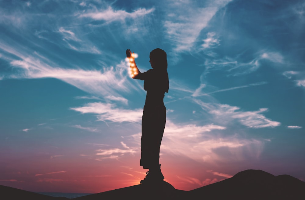 silhouette on woman standing on rock