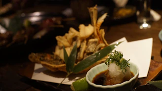 Golden crispy tempura pieces resting on a rustic wooden board.