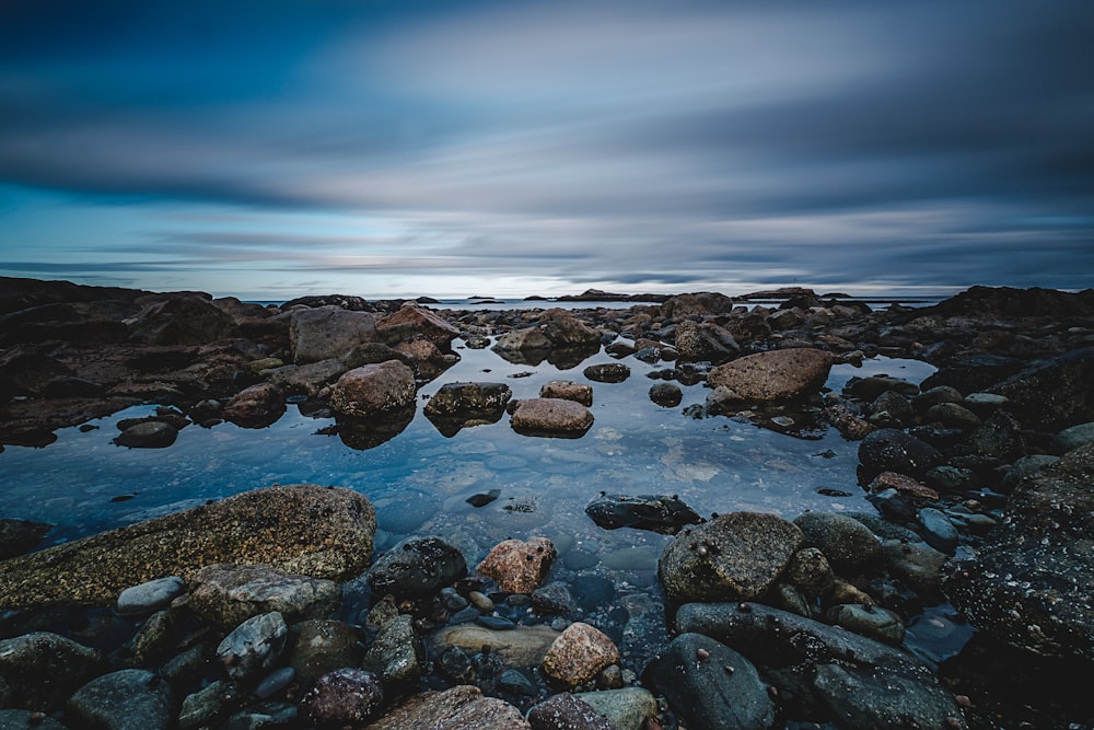 stone on coast under cumulus clouds