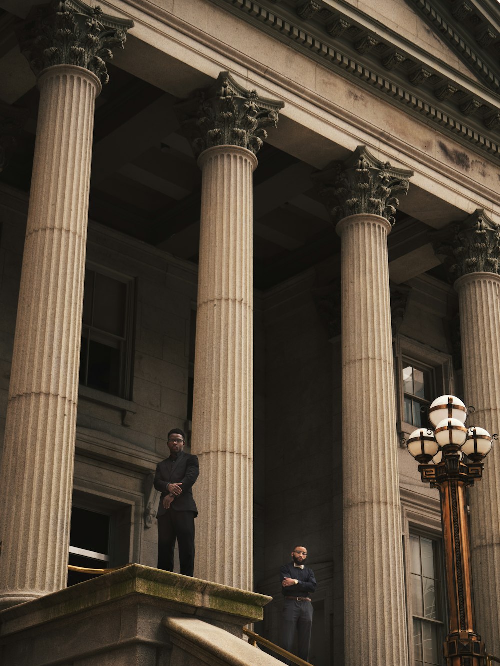 dos hombres de pie sobre el edificio de la columna corintia