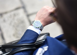 person looking at silver-colored analog watch