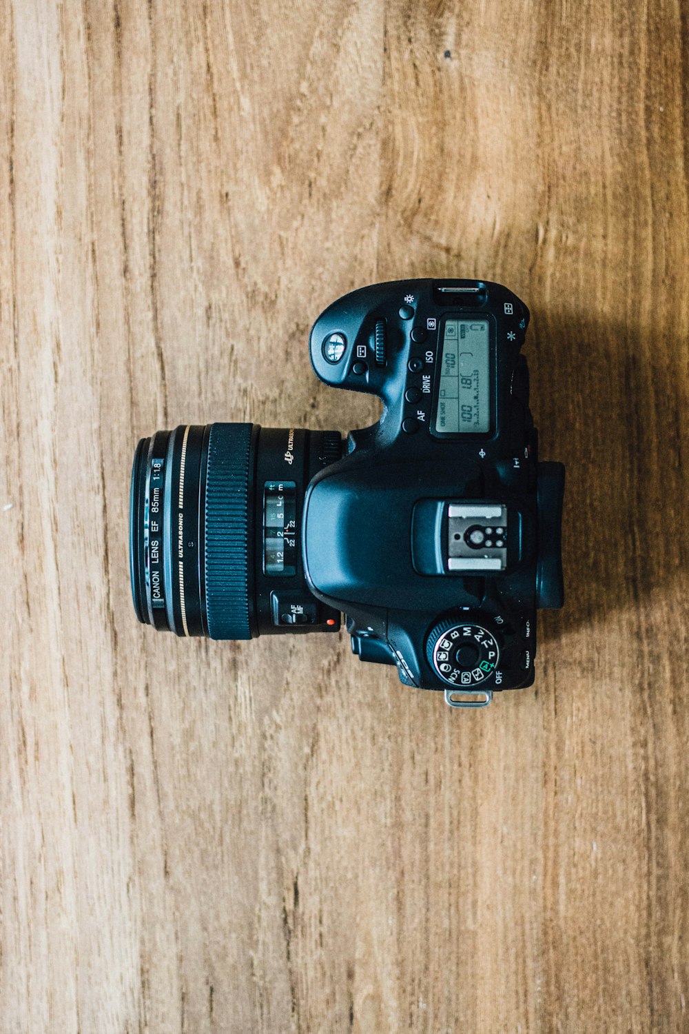 black dslr camera on brown wooden table