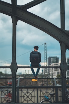 man sitting on top of bridge