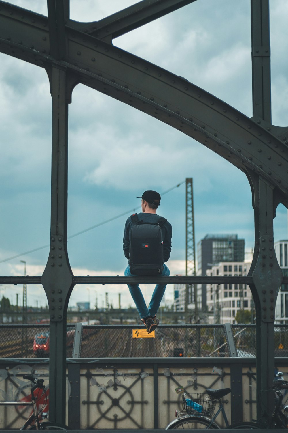 Mann sitzt auf Brücke