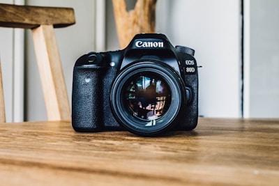 Canon DSLR camera on brown wooden table during daytime