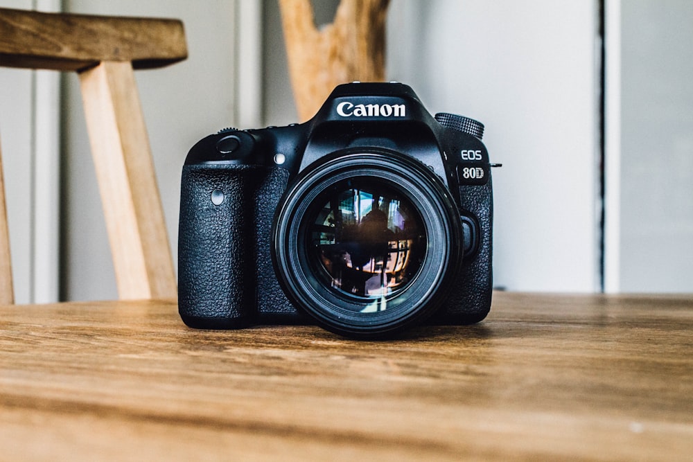 Canon DSLR câmera na mesa de madeira marrom durante o dia