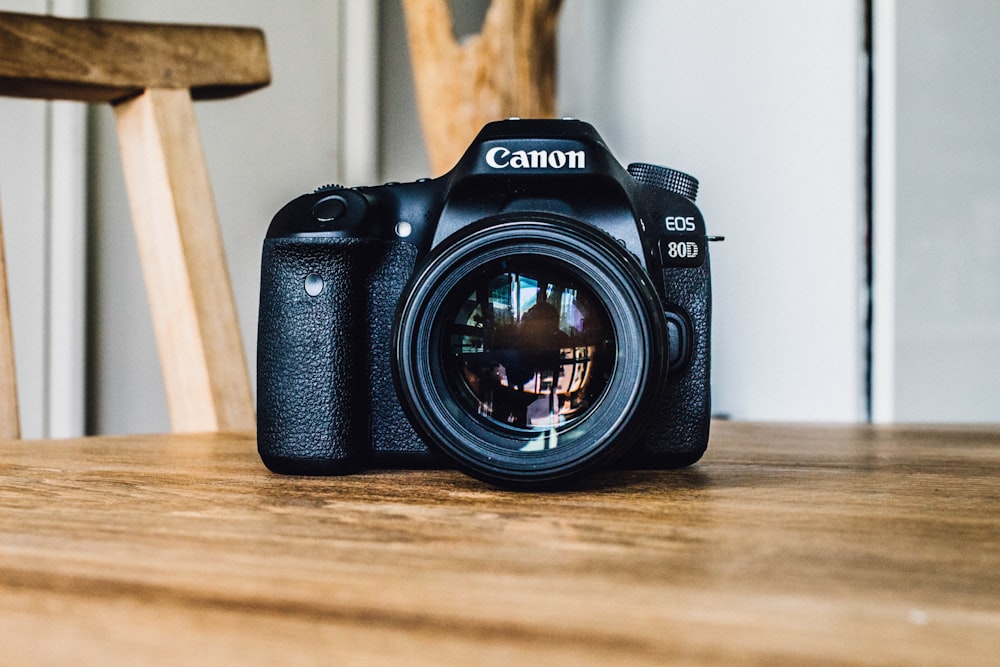 Canon DSLR-Kamera tagsüber auf braunem Holztisch