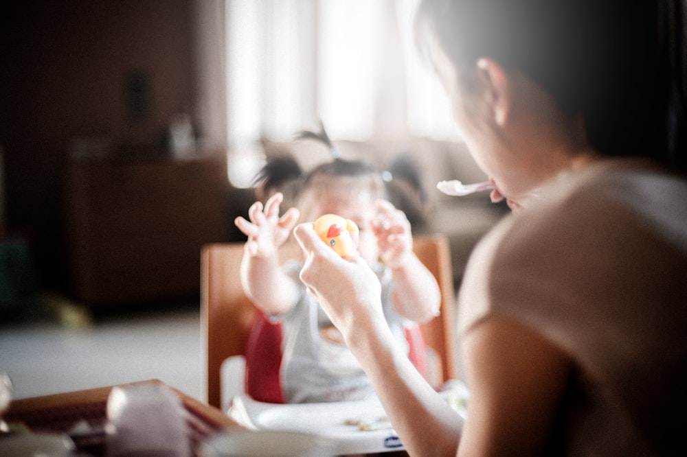 Fotografía de enfoque selectivo de mujer alimentando bebé