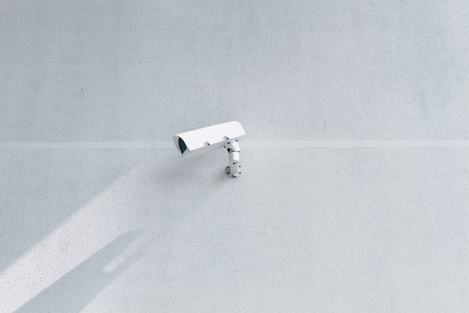 White box security camera on wall