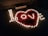An arrangement of small candles forms the word 'love' surrounded by heart petals on a textured surface. A box is placed near the arrangement, and the scene is dimly lit, creating a warm and intimate atmosphere.