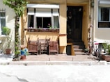 A welcoming front porch with potted plants and a wooden bench.