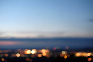 Soft-focus background with the Aperta logo subtly glowing behind a blurred cityscape at dusk.
