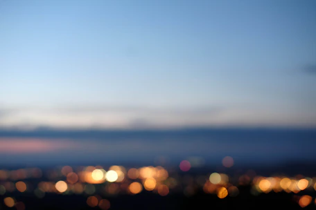 Soft-focus background with the Aperta logo subtly glowing behind a blurred cityscape at dusk.