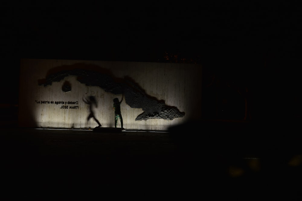 Children playing with their shadows against a wall