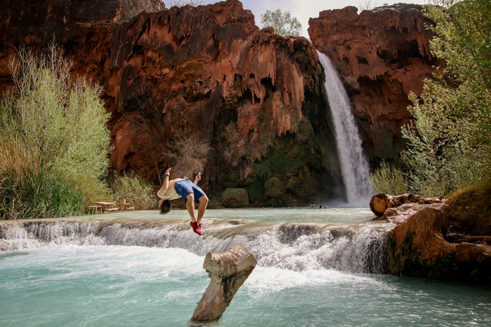 Mann taucht auf dem Wasser in der Nähe von Wasserfällen