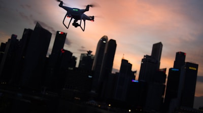 silhouette of drone hovering near the city at night