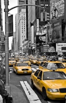 A busy city scene with taxis picking up passengers.