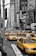 A busy city street with taxis and rideshare vehicles in motion.