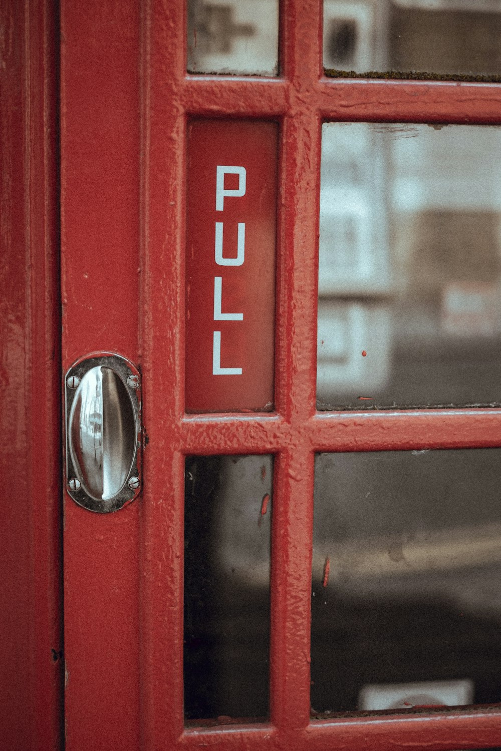 a close up of a red door with a metal handle