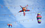 A colorful custom piñata shaped like a festive star hanging outdoors.