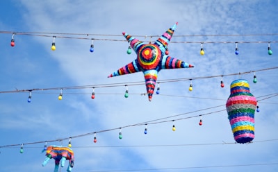 A festive scene showing children joyfully breaking a colorful piñata outdoors.