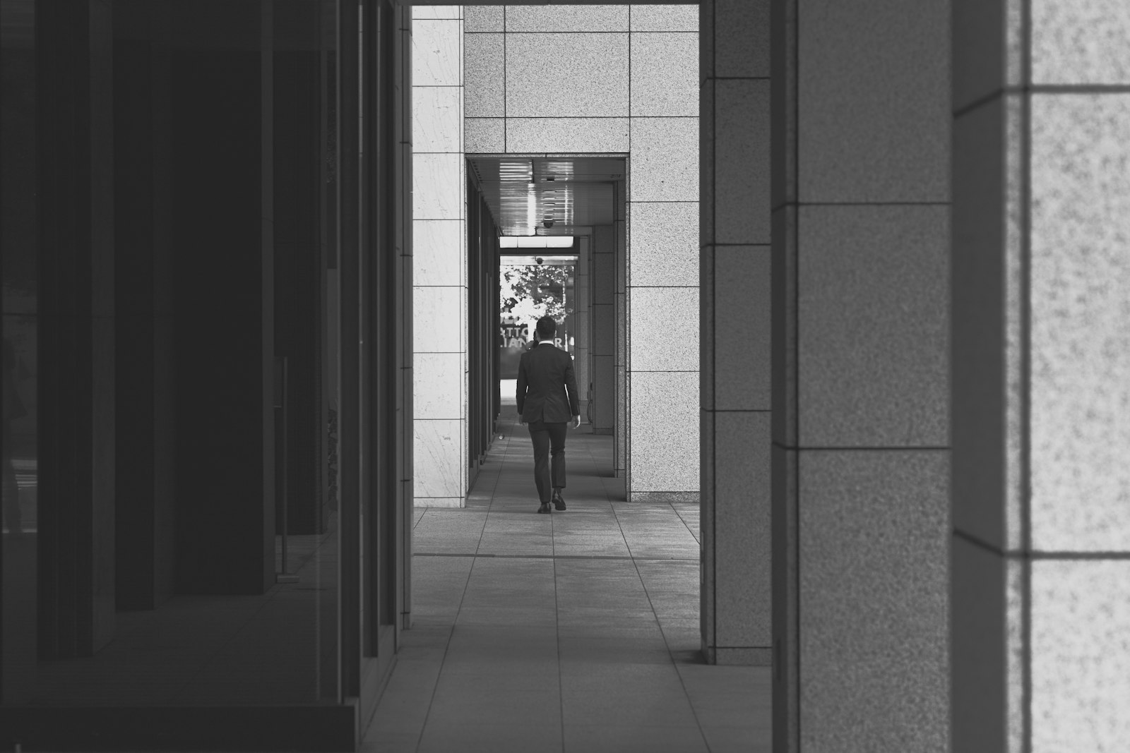 ZEISS Apo Sonnar T* 135mm F2 sample photo. Man walking on hallway photography