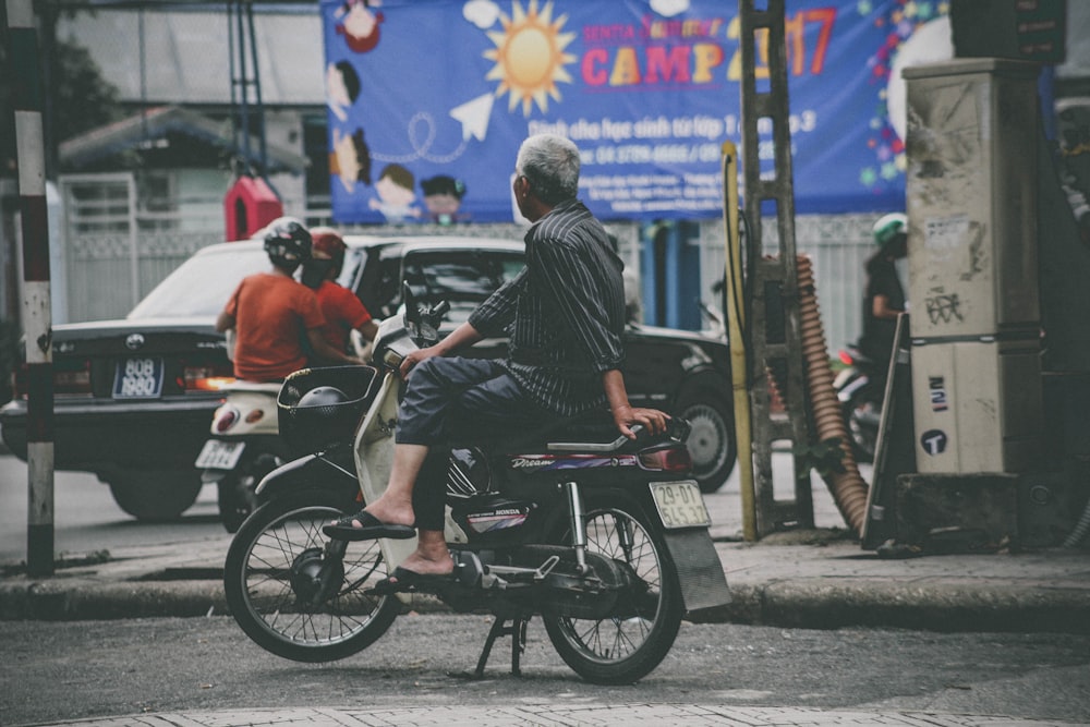 man riding white and black motor scooter