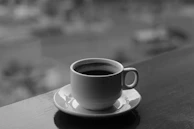 A quiet morning shot of a couple sipping coffee on a terrace with soft sand-colored walls.