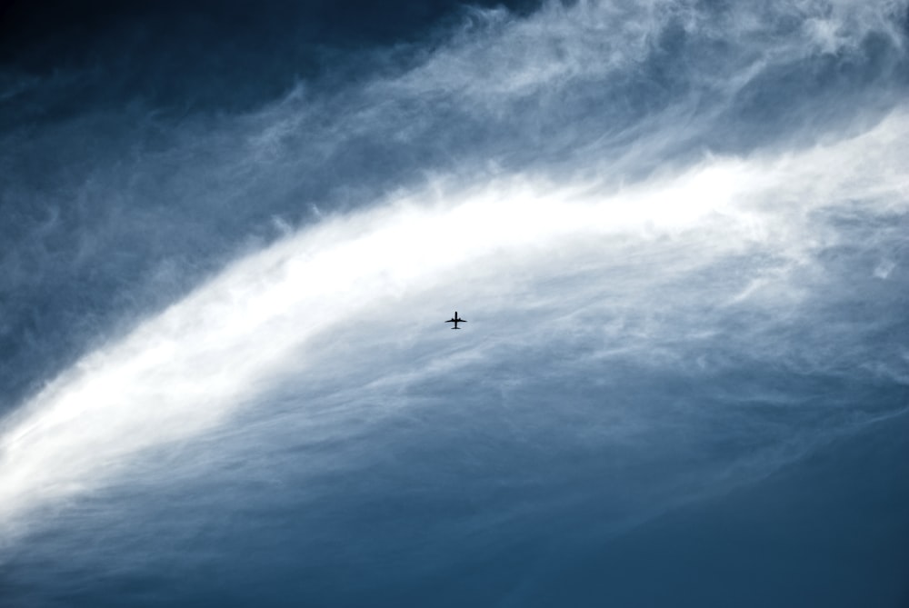 青空に浮かぶジェット機のシルエット