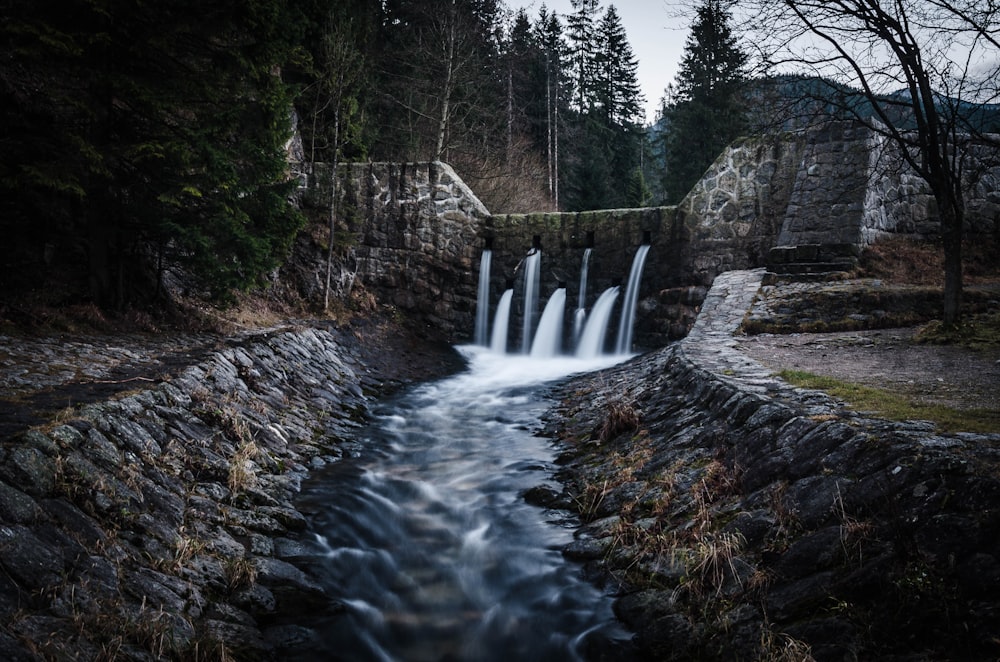 水が流れる灰色の石造りのダム
